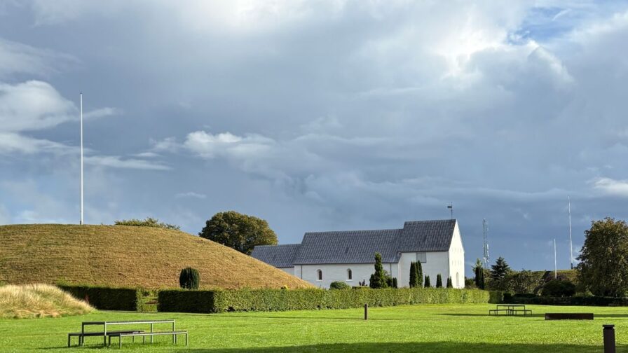 Grabhügel und weiße Kirche von Jelling – Teil des UNESCO-Welterbes in Dänemark