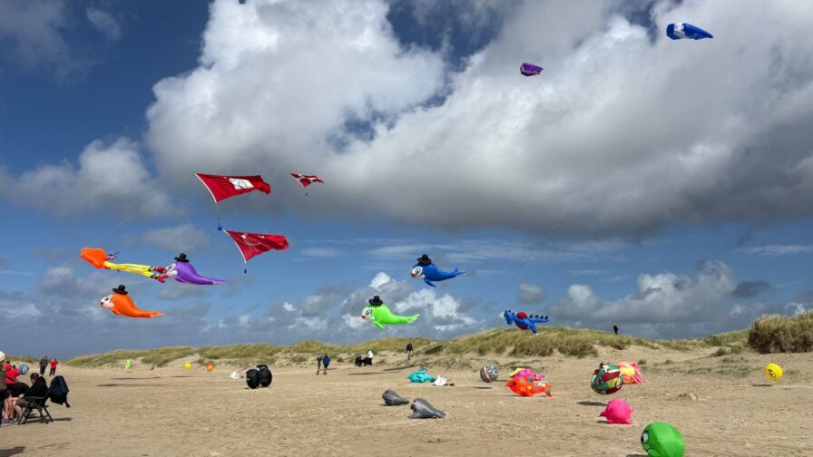 Bunte Figuren- und Großdrachen am Himmel über dem Strand von Lakolk beim Rømø Drachenfestival
