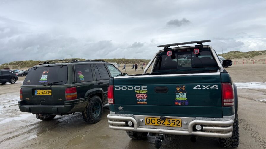 Geländewagen und Pickup als Abschleppfahrzeuge auf dem nassen Strand von Lakolk beim Rømø Drachenfestival