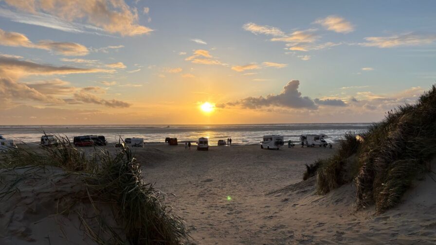 Sonnenuntergang über der Nordsee am Strand von Lakolk auf Rømø mit Wohnmobilen am Wasser